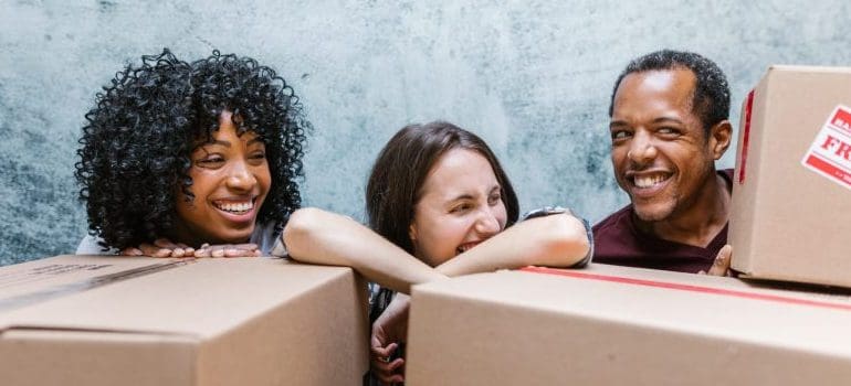 people smiling behind moving boxes