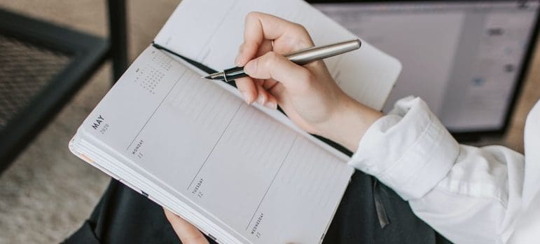 A woman writing moving day tips in her calendar