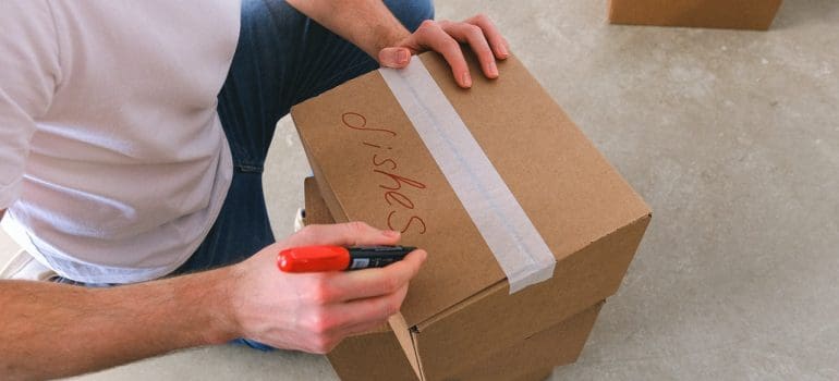 Person labeling a moving box.
