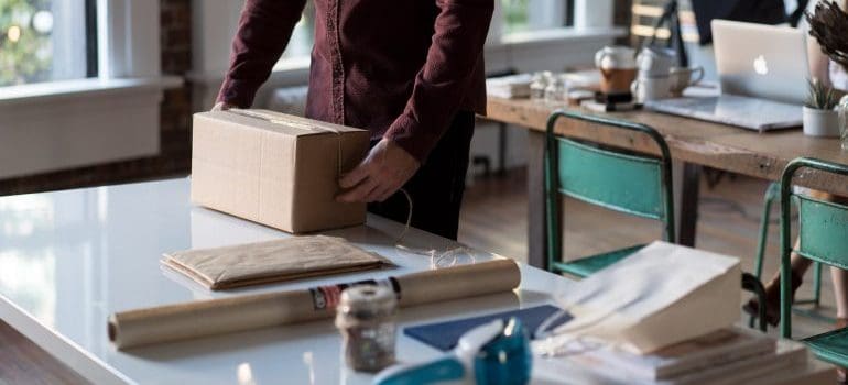 man packing in order to set up an office after moving to Queens