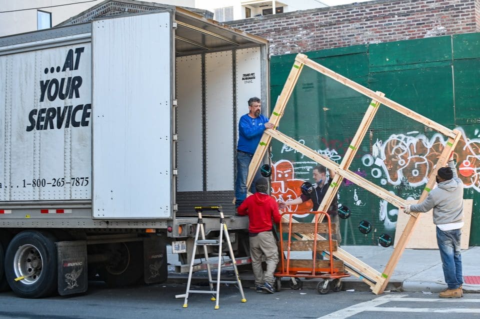 people moving a wooden frame