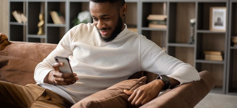 Man looking at his phone, searching for tips for hiring reliable movers in Manhattan