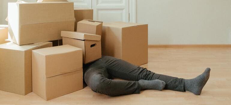 man covered with boxes knows why you should never move to Manhattan without help from professional movers