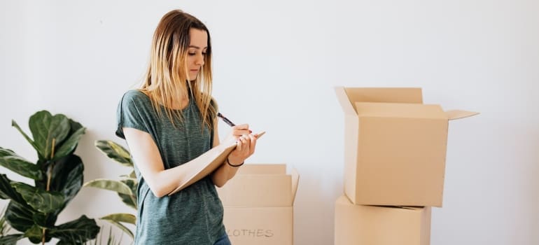 A woman writing a note while packing 