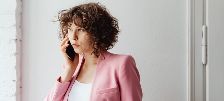 A woman talking on the phone, trying to compare Manhattan moving companies