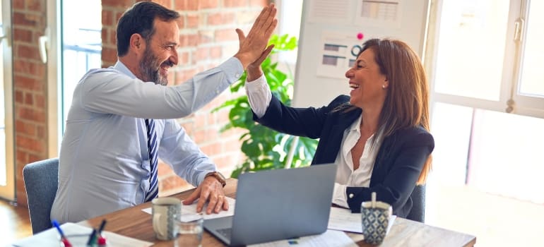 Two employees high fiving