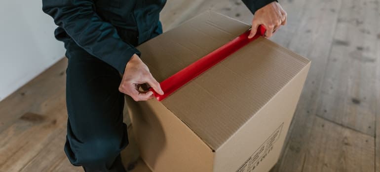 person packing cardboard box you shouldn't pack by yourself when moving interstate