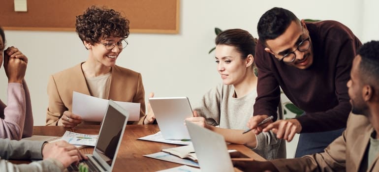 A group of people in an office talking to each other and thinking how their employees can participate in office relocation;