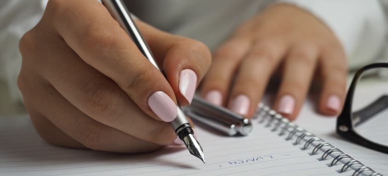 A woman writing a list in order to prepare for moving out of NYC after divorce