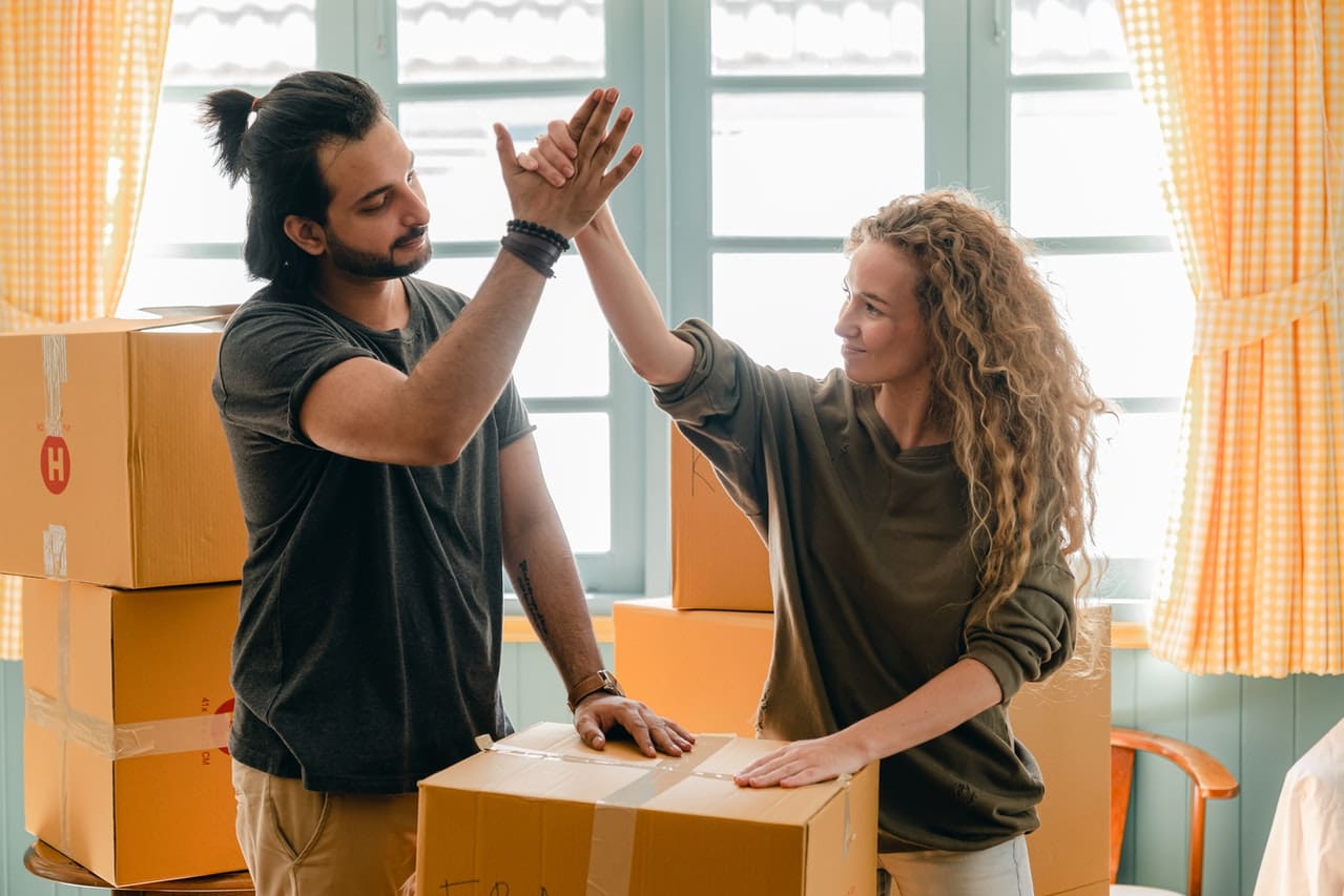 a couple high fiving and packing for the move