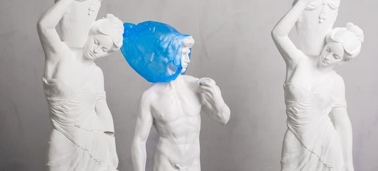 white statues with a blue bag
