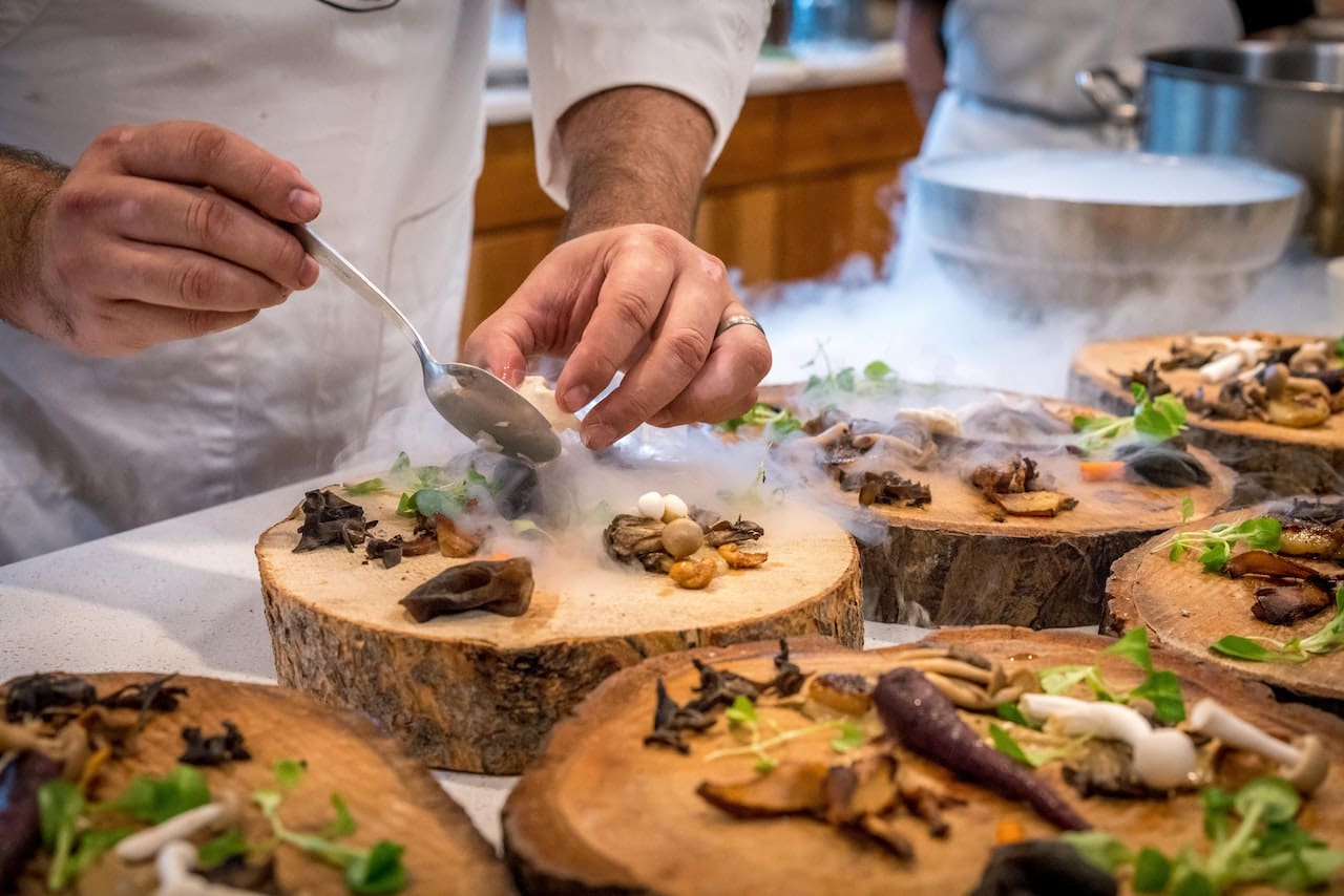 a chef placing food on a plate