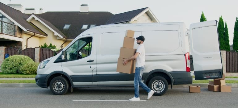 One of the SoHo movers carrying boxes to his van