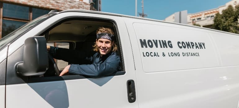 A moving company worker in a van
