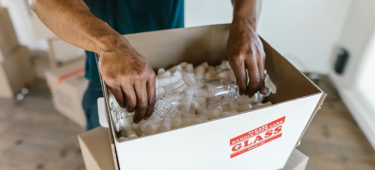 A man packing small glasses for vine