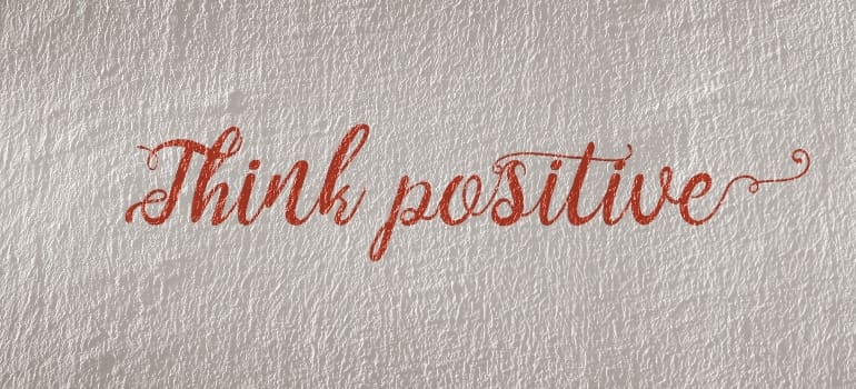 'think positive' written on the wall