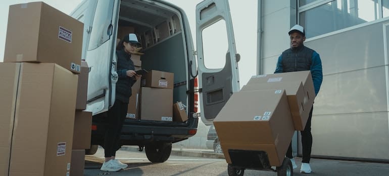 Movers un;oading boxes after moving to NYC from a small town