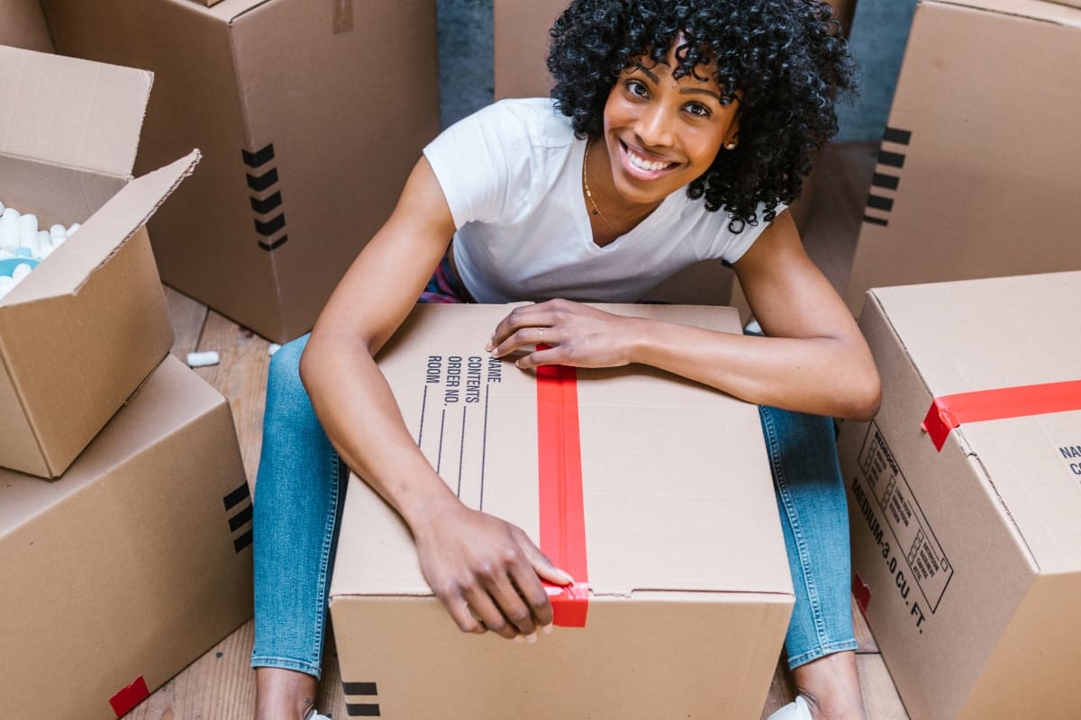 A woman sitting next to boxes